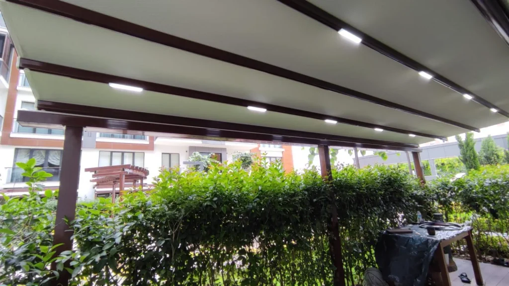 Pergola altında aydınlatmalı kirişler ve yeşil bitkiler
